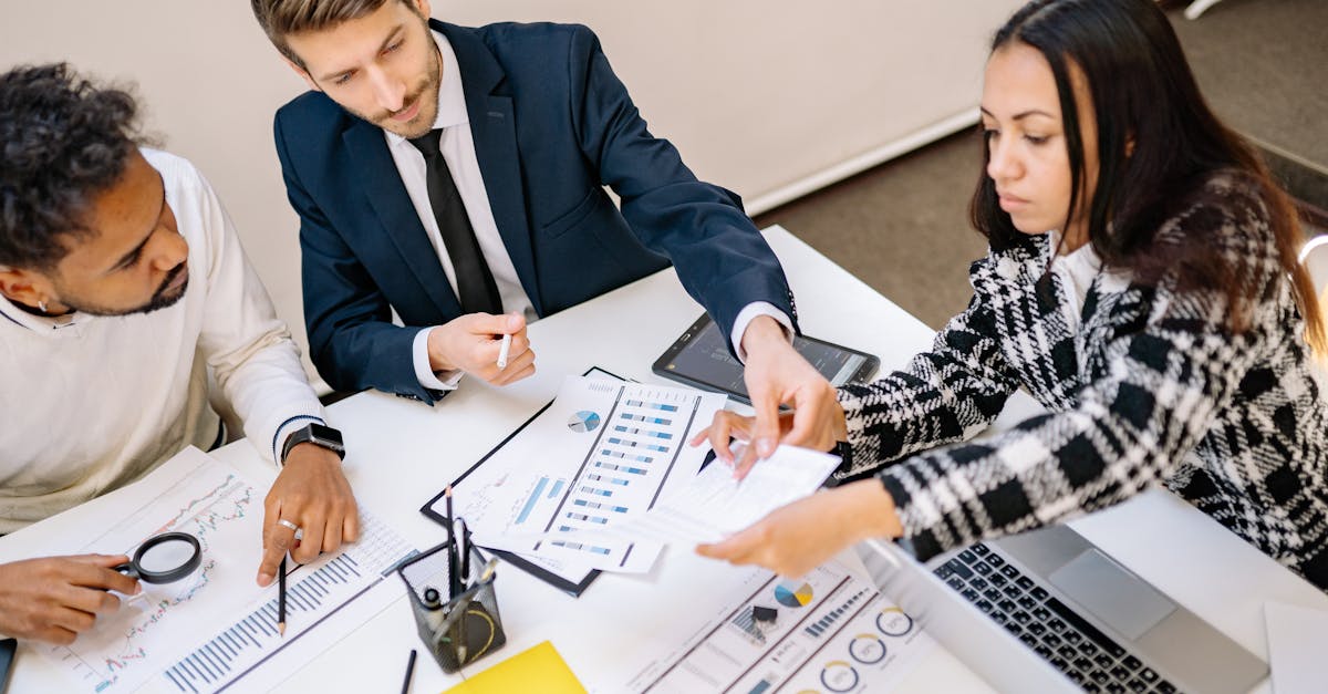 Business professionals engaging in a collaborative meeting with charts and documents.